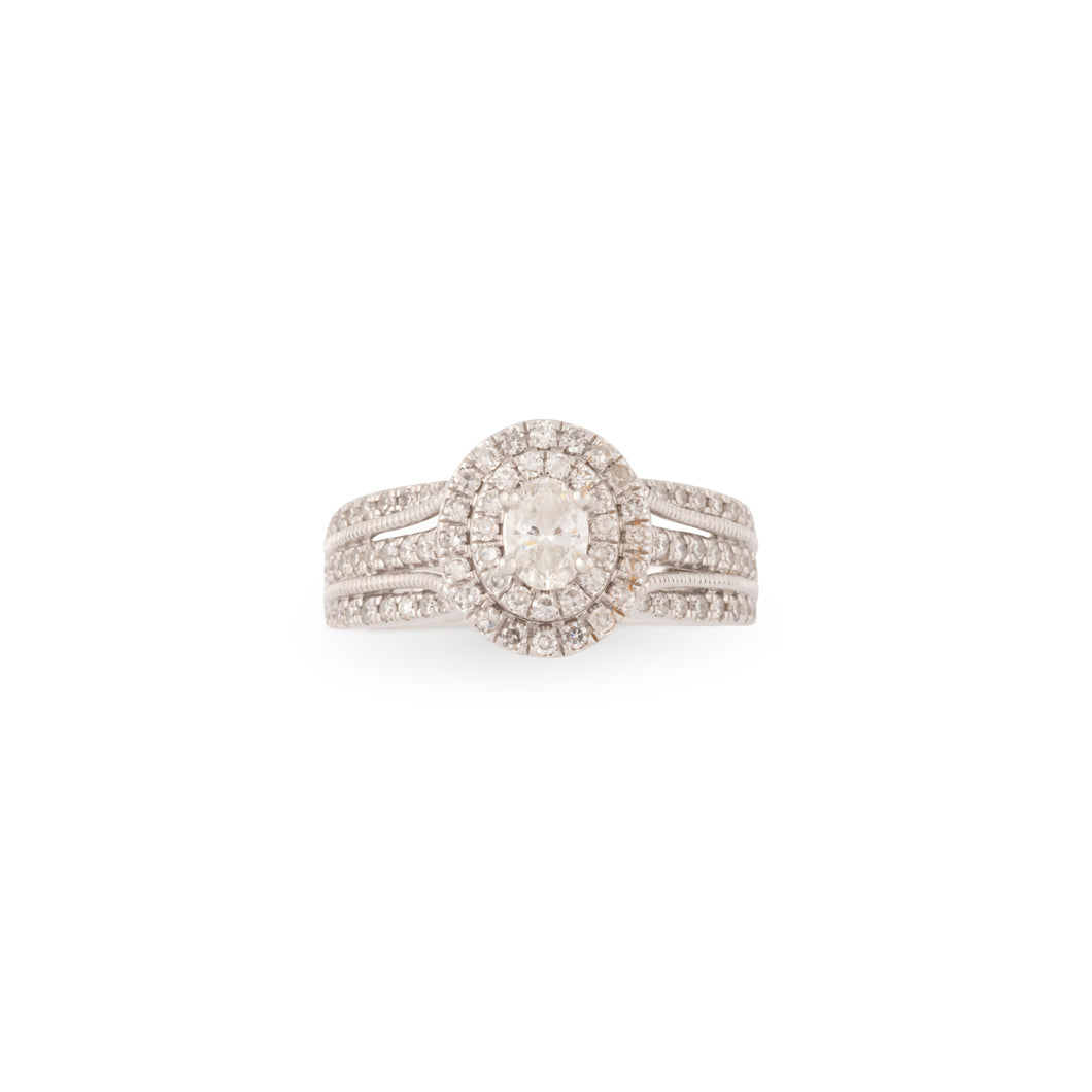 Bague en or gris ornée d'un diamant ovale et pavée de diamants