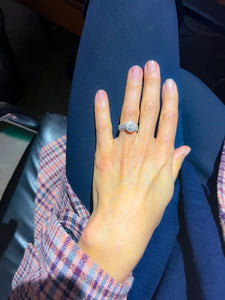 Bague en or gris ornée d'un diamant ovale et pavée de diamants