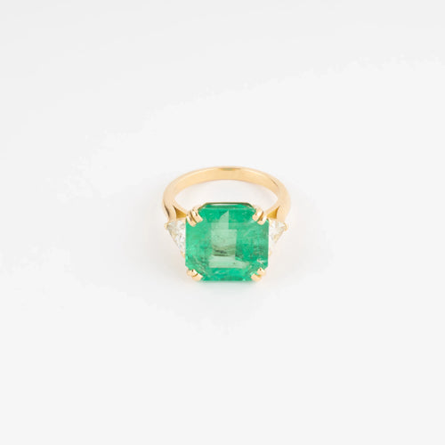 Bague en or jaune ornée d'une émeraude taille émeraude épaulé de diamants triangles
