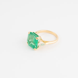 Bague en or jaune ornée d'une émeraude taille émeraude épaulé de diamants triangles