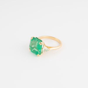 Bague en or jaune ornée d'une émeraude taille émeraude épaulé de diamants triangles
