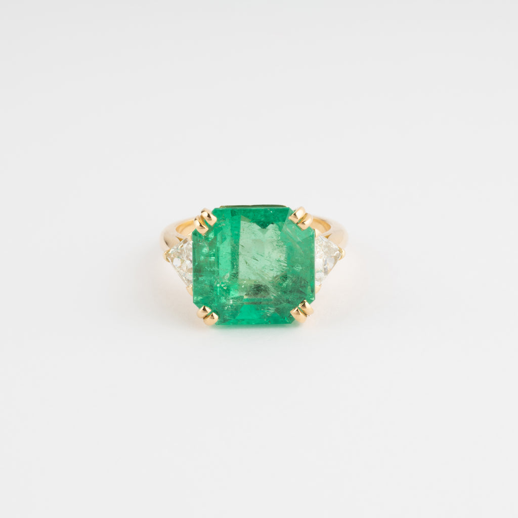 Bague en or jaune ornée d'une émeraude taille émeraude épaulé de diamants triangles
