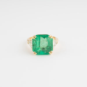 Bague en or jaune ornée d'une émeraude taille émeraude épaulé de diamants triangles