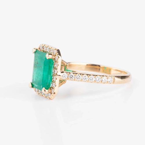 Bague en or jaune ornée d'une émeraude entourée de diamants